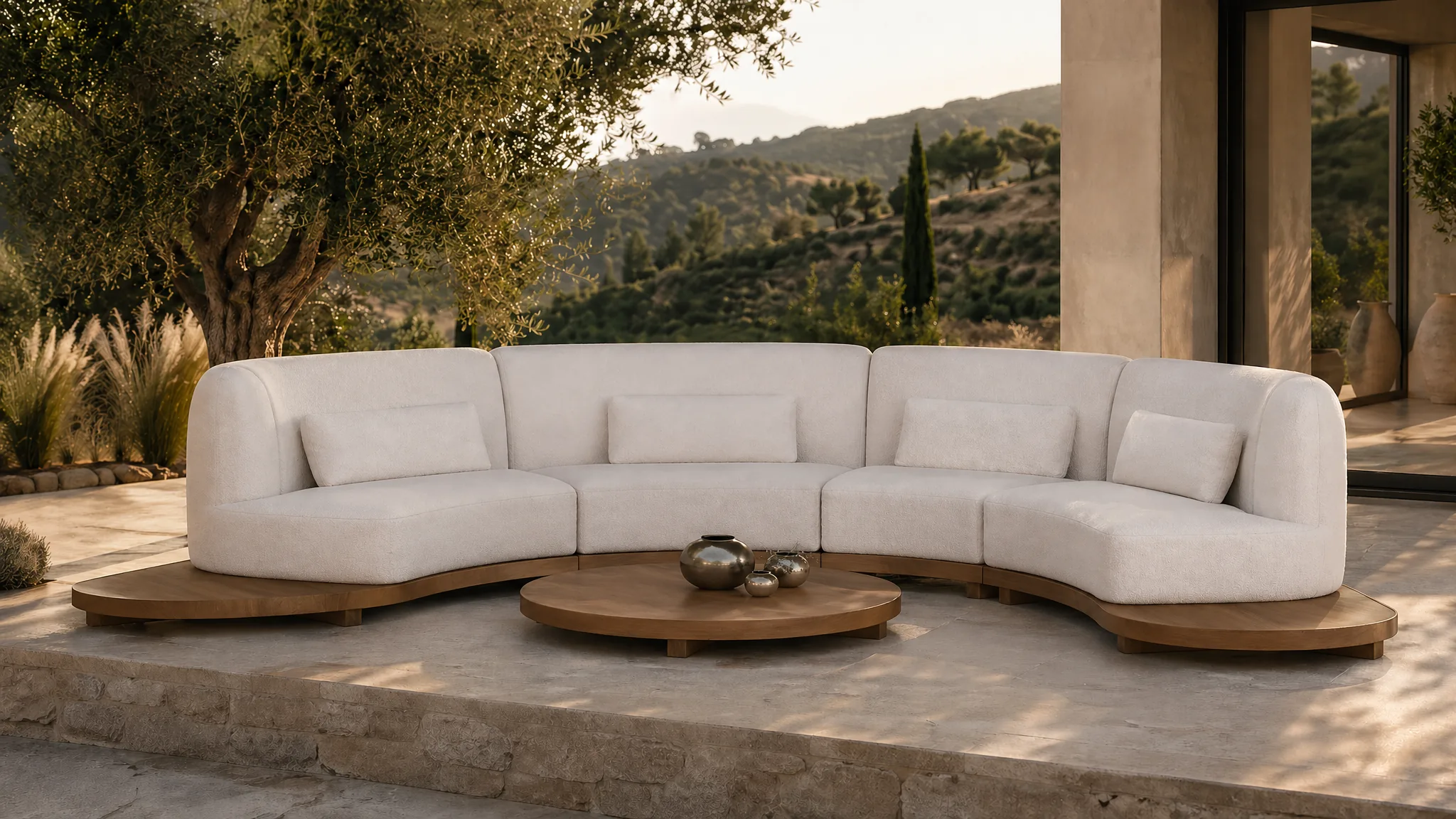 Canapé modulaire en U en bois d'acacia sur terrasse en pierre, oliviers, paysage méditerranéen golden hour